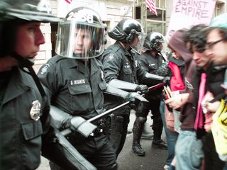 Cops using sticks to contain demonstrators.