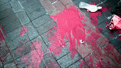 Another potential paint bomb filled with red paint did not make its target, having been smashed on the ground, with its contents splattered all over the sidewalk.