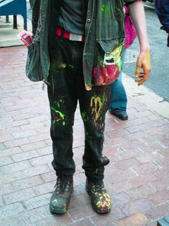 A demonstrator stands covered in paint following the breaking of several paint bombs.