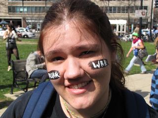 A woman's face is painted with "FUNK WAR" on her cheeks.