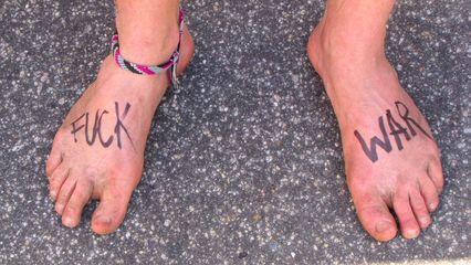 A simple, if slightly uncouth, anti-war message written on a pair of feet.