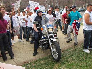 Officer Gallo arrives on a motorcycle, with cans of pepper spray on board.