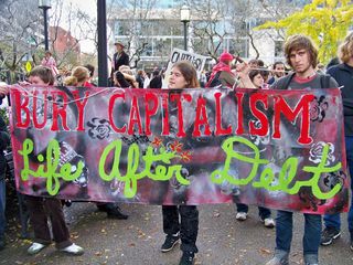 "Bury Capitalism: Life after Debt" banner.