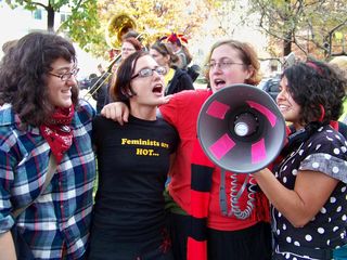 Radical cheerleaders sing a song into the bullhorn.