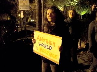 A mainstream demonstrator holds a sign as the march begins to stall.