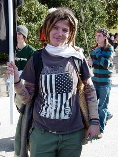 A woman holds a black flag while wearing another Anti-Flag shirt.