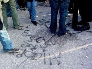 "All cops are pigs" and a middle finger are spray painted in black onto the Capitol steps near the other message.