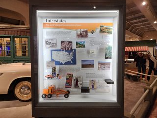 This is the display where my photo appears, discussing the Interstate Highway System.  It contains my photo of Breezewood from 2006 at center right.  My name is superimposed over the right side of the photo, and it's captioned, "Small cities of food, gas, and lodging chains arose where major highways intersected.  This is Breezewood, Pennsylvania, 2006."