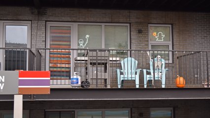 An apartment balcony overlooking Belmont station, still decorated for Halloween.