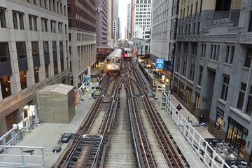 The same Purple Line train approaches the big interlocking at Lake and Wells, as a Brown Line train passes on the other track.