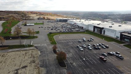 The rest of the former shopping center, facing approximately south.  The grass strip that runs across the middle of the shot serves as a divider between the retail and industrial sections of the property.