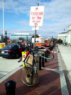 This was a very creative bicycle parking job, no? It was chained to, of all things, a "no parking" sign. Security guards were about to remove this bicycle when I came by for the photo. I managed to talk them into waiting the few seconds for me to take the photo of the amusing lock job before removing it.