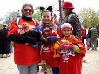 Some people held other representations of puppet characters, such as this family, which carried stuffed animals based on Sesame Street's puppet characters.