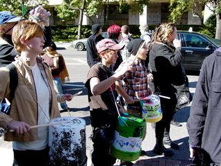Participants in the feeder march beat on makeshift drums and shout at the meet-up location outside AFL-CIO headquarters.