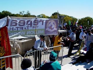 The large banner blocking the view of the speakers was the official Million Worker March banner, which had the movement's logo on it (four hands holding onto each other), and large text reading, "Repeal the Taft-Hartley [Act]".