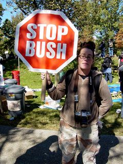 This woman simply holds up a stop sign, reading "STOP BUSH".