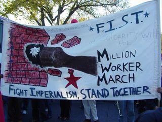 A large banner carried by some marchers, with the theme FIST: Fight Imperialism, Stand Together.