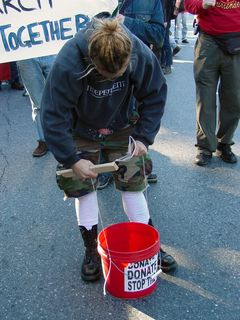 Jess takes a moment to adjust the twine on her makeshift drum, which she was unable to tie securely.