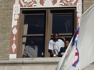 Three Hotel Washington employees lean out of a third-story window, lending support to our efforts to support them. Based on the expressions on their faces, you could tell that these workers were glad to see us coming.