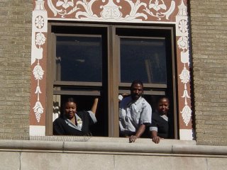 Three Hotel Washington employees lean out of a third-story window, lending support to our efforts to support them. Based on the expressions on their faces, you could tell that these workers were glad to see us coming.