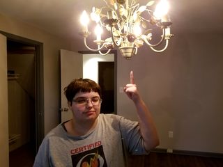 Elyse points at the chandelier in her new bedroom during the final walkthrough.