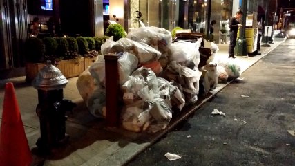 Bagged trash piled up in front of the aforementioned Hilton Garden Inn.