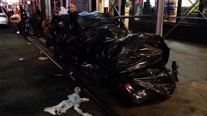 Bagged trash in front of another business.