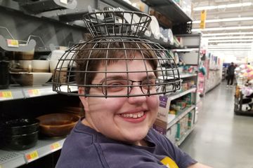 Elyse wears a fruit basket on her head at Walmart.