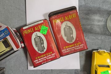 Two tins that once contained Prince Albert brand cigarette tobacco.