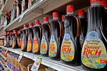 Bottles of Pearl Milling Company syrup on the shelf at Piggly Wiggly, with one bottle's still carrying the older Aunt Jemima name.