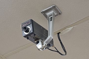 Vintage Sanyo security camera on the ceiling near the checkouts.