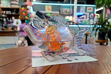 A glass fish sculpture on one of the tables.