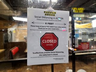 Social-distancing signage on the door, being used to indicate that the restaurant was closed.