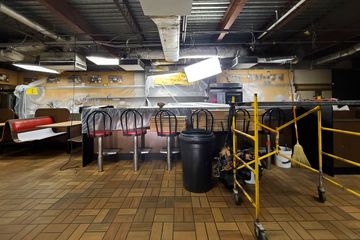 The interior of the restaurant, with the entire ceiling removed and the walls covered.