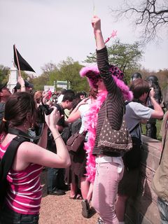 Meanwhile, Code Pink activist Midge Potts holds up a sign stating "Unity Through Diversity".