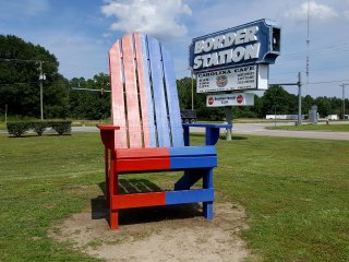 Adirondack chair straddling the border, with the red-painted side in Virginia, and the blue-painted side in North Carolina.