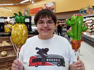 Elyse poses with pineapple and cactus balloons.