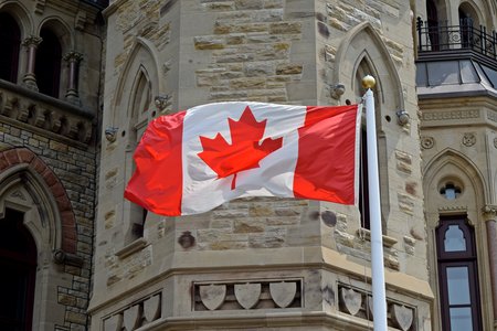 The Canadian flag flies next to the West Block building of Parliament in Ottawa.