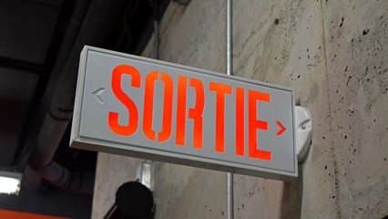 French-language exit sign at the Gatineau Sports Centre.  From what we could tell, exit signs in Quebec were textual, and used "SORTIE", which is French for "exit".  Compare to Ontario, which has adopted the green "running man" pictogram for exit signage.