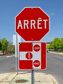 Quebec-style signage for a three-way stop, showing stops at all three entries to the intersection.