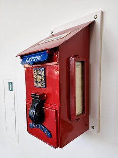 A small Canada Post mailbox in the museum's main lobby.  Note the creative way that the designers made it bilingual, with the parts of the word that were the same in large text, and smaller text where the two words differ.