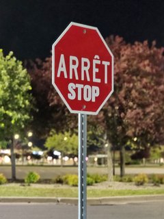Stop sign as we were exiting the Walmart parking lot.  I got the sense that the shopping center owners acquired a stop sign intended for use in Quebec, and then hastily modified it to carry the English wording as well.