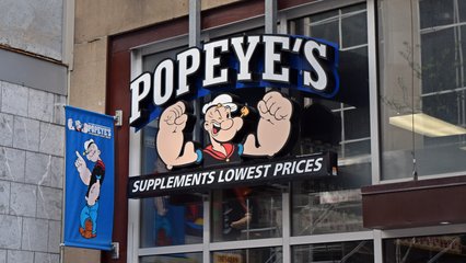 Sign for Popeye's Supplements, a chain of health food stores using Popeye the Sailor as its mascot.  The store sells products similar to those at GNC.