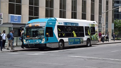 STO bus 2210, a NovaBus LFS HEV, services a stop at the corner of Albert Street and Bank Street while operating the 55 route.  STO, short for Société de transport de l'Outaouais, is the public transit system in Gatineau, and many routes also service parts of Ottawa.