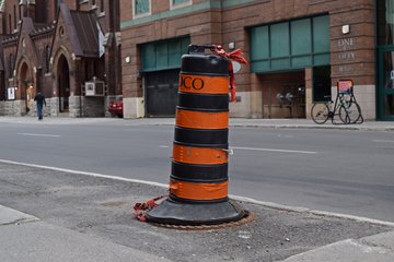 Ontario-style construction barrel.  Compared to what we see in the States, these are taller and skinnier, and have orange and black stripes.