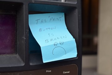 Sticky note on another pay station nearby, indicating that the print button is broken, along with a drawing of a sad face.