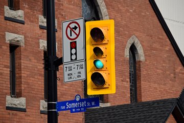 Four-aspect traffic signal at the intersection of Elgin Street and Somerset Street West.  Note that the left-arrow aspect is the same size as the red aspect.
