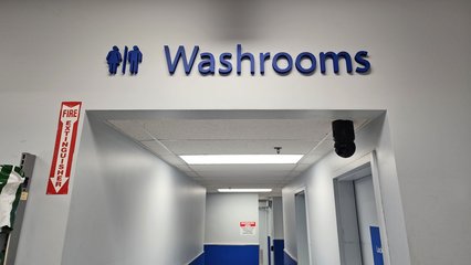 "Washrooms" signage over the corridor leading to the restrooms.