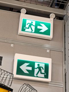 Ontario and Quebec-style exit signs on display at Réno-Dépôt.  Ontario uses the green "running man" icon for exit signs, while Quebec uses text-based exit signs that say "SORTIE".