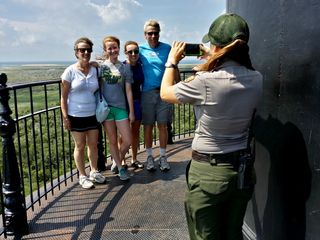 A park ranger helps a family get a photo on the balcony.